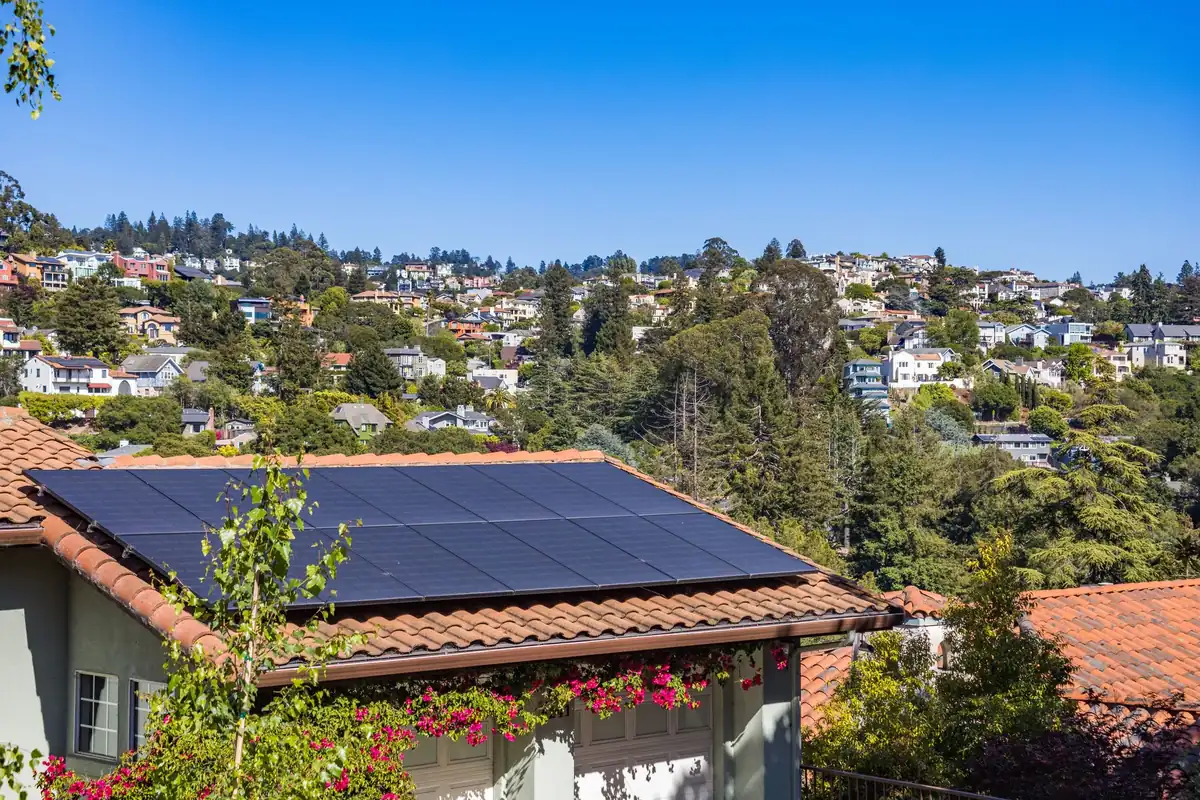 Illustrative photo of rooftop solar panels on a sunny detached house. Not a Complete Electrical installation.